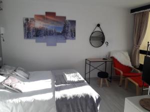 伊索拉2000Appartement 4/6 pers plein sud. Front de neige的一间卧室配有一张床、一把椅子和一幅画