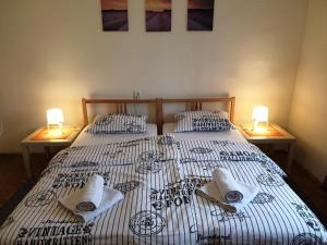 卢布尔雅那Sašo Rooms & Apartments的一间卧室配有两张带毛巾和两盏灯的床。