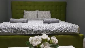 德米尔卡皮亚Villa Bratislava的一张带两个枕头的绿床和花瓶
