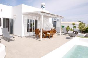 查德尔帕罗奥Villa Tranquilidad with amazing private terrace and heated pool的游泳池旁带桌椅的天井