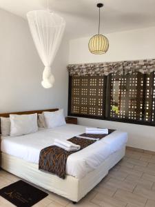 普拉伊拉多比莱尼Villa Espanhola Bilene的卧室设有一张白色大床和一扇窗户。