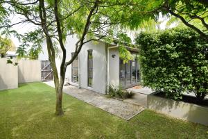 基督城Hagley Apartment - Christchurch Holiday Homes的院子里有树的房子