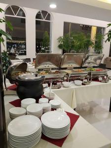 金边Apple Hotel Three - near PNH airport的自助餐,包括白盘和一壶食物