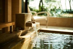 志摩市THE HIRAMATSU HOTELS & RESORTS KASHIKOJIMA的一座房子里泳池里的喷泉