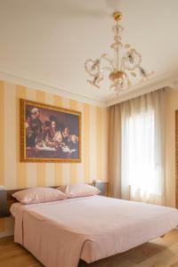 Campo San MartinoLittle House的卧室配有一张大床,墙上挂有绘画作品