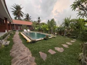乌布Ayuna Family Ubud的一个带游泳池和房子的后院