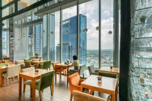 新加坡Oasia Hotel Novena, Singapore by Far East Hospitality的餐厅设有桌椅和大窗户。