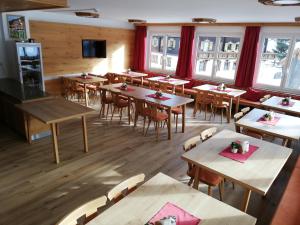 大格洛克纳山麓卡尔斯Wurlerhof的一间空餐厅,配有桌椅和窗户