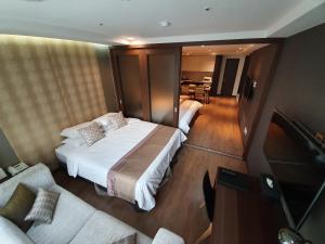 首尔江南欧克劳德酒店的一间卧室设有一张床和一间客厅。