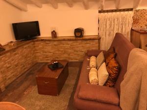 塞埃欣Nuestra Casita de Papel的客厅配有棕色沙发和电视