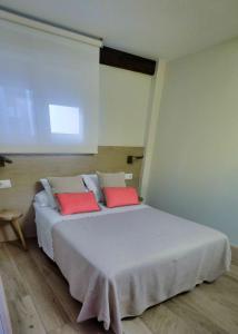 潘普洛纳Atico Estafeta的一间卧室配有一张大床和两个红色枕头