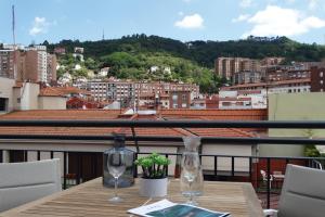 毕尔巴鄂Bilbao City Center by abba Suites的阳台上的桌子和两杯酒杯