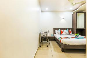 孟买FabExpress Adore Inn的一间卧室配有一张床和一张带镜子的书桌