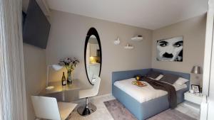 苏黎世VISIONAPARTMENTS Rotachstrasse - contactless check-in的一间卧室配有一张带书桌和镜子的床