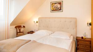 科隆豪斯英格鲍格艺术康福特酒店的卧室设有一张白色大床和楼梯。