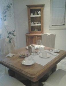 CarosinoBB La casa di Tella的一张木桌,上面有盘子和玻璃杯