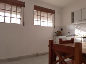 布兰卡港Roberta 3的厨房拥有白色的墙壁和窗户,配有木桌