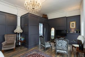 贝尔法斯特The Warren Belfast的客厅设有蓝色的墙壁、椅子和吊灯。