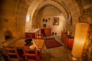 乌奇希萨尔Asmalı Cave House的客房内的厨房配有桌子和炉灶