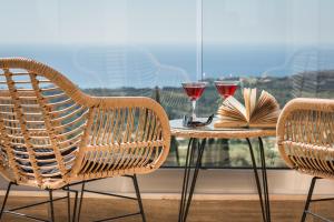 特拉佩扎奇Diana Suites的一张桌子、两把椅子和两杯葡萄酒