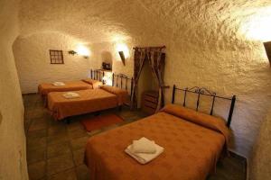 GaleraAlojamiento Cuevas Victoria的一间卧室,配有三张床
