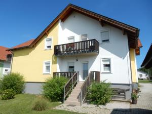路茨曼贝格Appartement Huber的黄色和白色的房子设有阳台