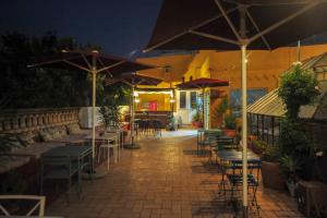 塞维利亚拉弗拉蒙卡旅馆的露台在晚上配有桌椅和遮阳伞