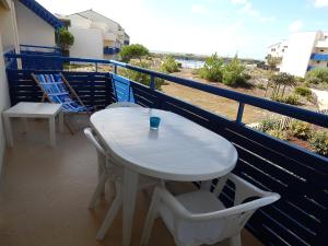 拉卡诺Appartement T 2 AVEC PISCINE的海滩阳台的白色桌椅