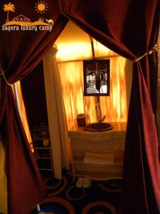 扎古拉Sahara Luxury Camp的带窗帘的客房内设有带水槽的浴室