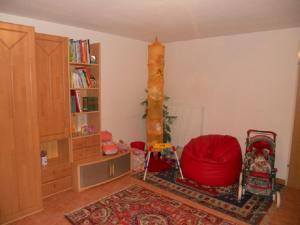 路茨曼贝格Appartement Huber的客厅配有红色椅子和书架