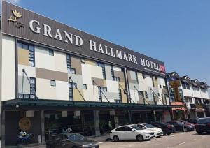 新山Grand Hallmark Hotel - Johor Bahru的停车场内停放汽车的大型建筑