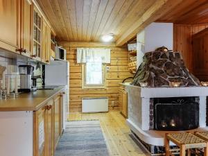 Raanujärvi皮尔欧拉度假屋的小木屋内带壁炉的厨房