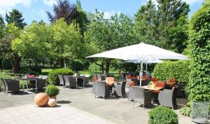 汉堡Bundt's Hotel & Gartenrestaurant的一个带桌椅和遮阳伞的庭院
