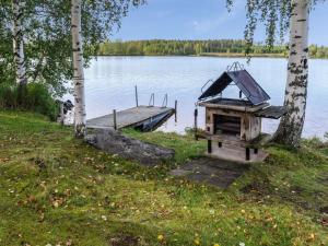 RuvaslahtiHoliday Home Iltarauha by Interhome的湖畔的烧烤架,带码头