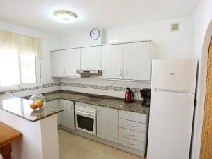 利乌玛Holiday Home Vicky by Interhome的厨房配有白色橱柜和白色冰箱。