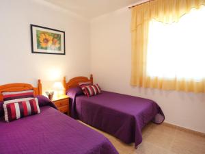 利乌玛Holiday Home Vicky by Interhome的一间卧室设有两张带紫色床单的床和窗户。