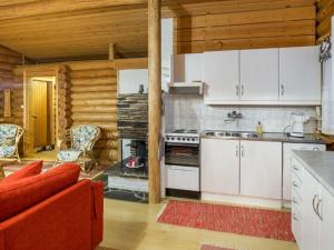 锡尔卡Holiday Home Honkakeko by Interhome的厨房配有白色橱柜和红色沙发
