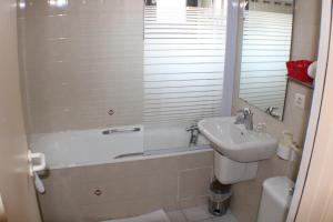 Ispagnac拉斯维吉内罗吉斯酒店的一间带水槽、浴缸和卫生间的浴室