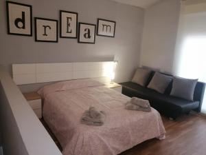 穆尔西亚Casa de la huerta的一间卧室配有一张床和一张沙发,墙上挂着图片