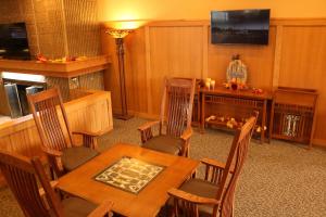 阿斯彭阿尔皮纳华美达酒店的一间带桌椅和电视的用餐室