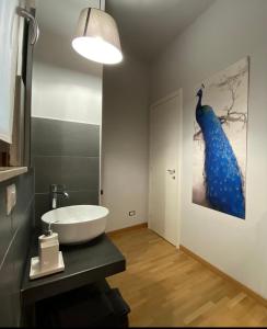 博尔戈马内罗Momi的浴室设有水槽,墙上挂着蓝色孔雀画