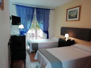 圣玛丽亚港阿拉哈海滩旅馆的酒店客房设有两张床和窗户。