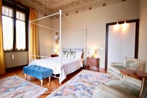 Cadegliano ViconagoVilla Farinelli的一间卧室配有天蓬床和蓝色凳子