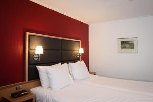 Olterterp赫特维特惠斯餐厅酒店 的一张位于酒店客房的床位,设有红色的墙壁