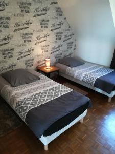 洛里昂Le Sleepway Lorient的客房内的两张床,墙上有签名