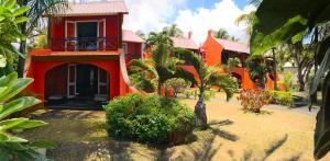 蒙舒瓦西Flowers of Paradise的前面有棕榈树的红色房子