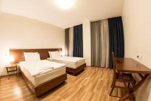 古多里Hotel Deka的酒店客房配有两张床和一张书桌