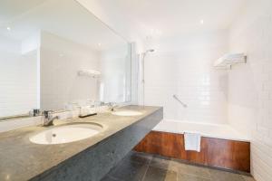 利尔Hotel Hof van Aragon的一间带两个盥洗盆和大镜子的浴室