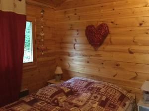 旺特龙Chalet le val’tin的小木屋的卧室,墙上有心