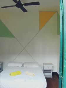 罗萨里奥自由旅舍的一间卧室配有一张带吊扇的床